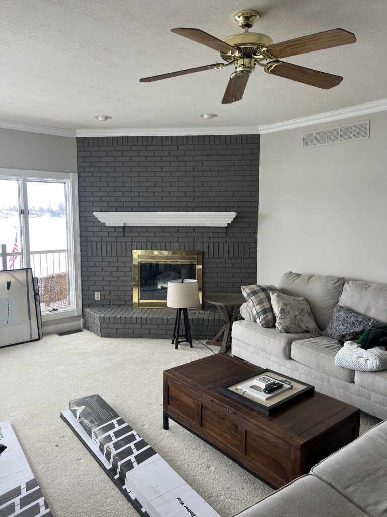 Living room with charcoal painted brick fireplace and white mantel by Heritage Painting